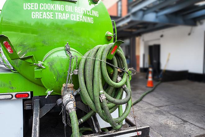 a grease trap being pumped by a sanitation technician in Penfield